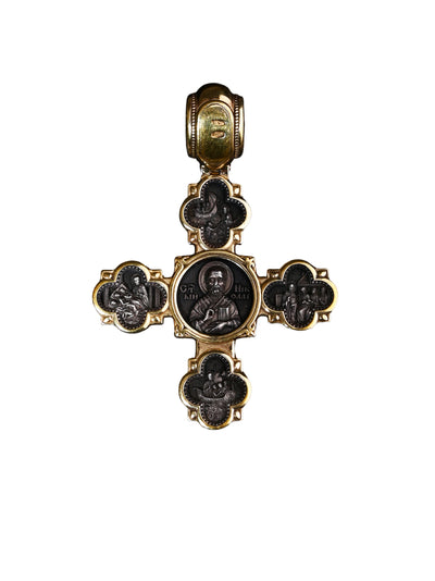 Decorative cross pendant with religious iconography on a white background